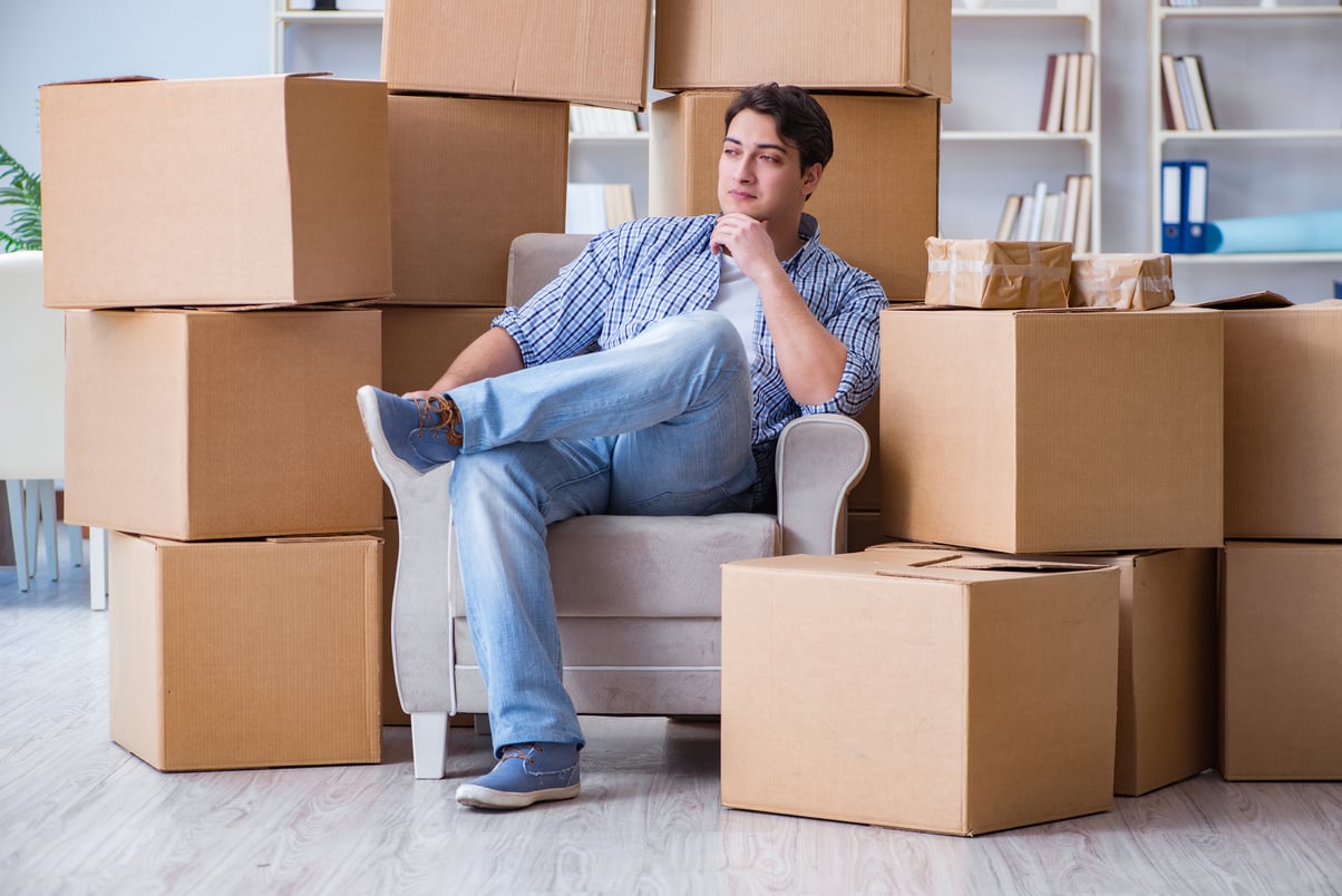 Young Man Moving in to New House with Boxes